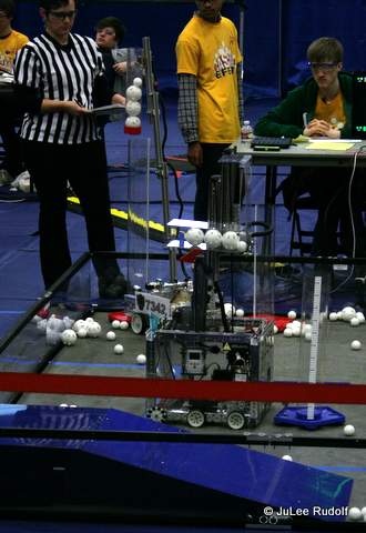Robots attempt to place balls in rolling goals